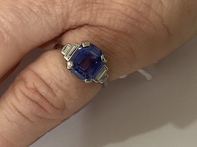 Lot 45 - A sapphire ring with two baguette cut diamonds in each shoulder.