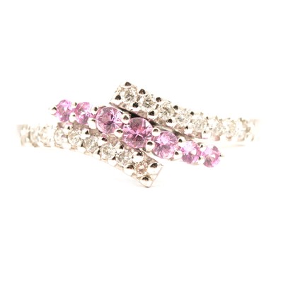 Lot 78 - A pink sapphire and diamond crossover ring.