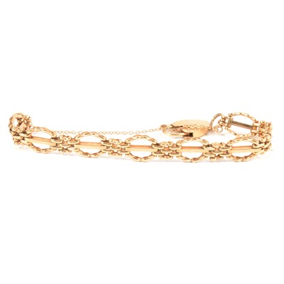 Lot 334 - A 9 carat yellow gold three bar textured gate link bracelet.