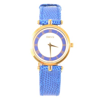 Lot 395 - Gucci - a lady's gold-plated  watch with blue chapter ring and strap, model 2000M.